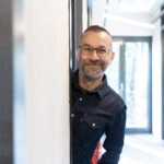 Lächelnder Mensch, der aus dem Türrahmen schaut