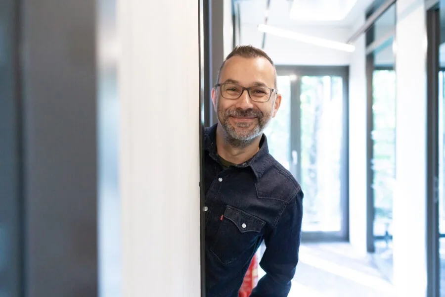 Lächelnder Mensch, der aus dem Türrahmen schaut